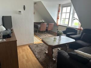 ein Wohnzimmer mit einer Couch und einem Tisch in der Unterkunft Ferienwohnung am Alten Hafen in Hooksiel