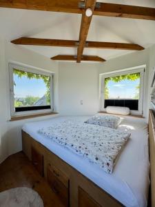 Cama en habitación con 2 ventanas en Turm auf altem Bauernhof, en Götterswickerhamm