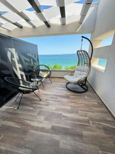 a room with two chairs and a view of the ocean at Olive Villas Beach Hotel in Sozopol