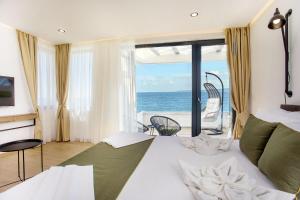 a bedroom with a bed and a view of the ocean at Olive Villas Beach Hotel in Sozopol