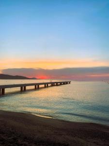 une jetée s'étend sur l'océan au coucher du soleil dans l'établissement Rêve D'azur, en Bord de Mer à La Nartelle, Piscine, Parking & Terrasse BBQ, Wifi et Draps Inclus plage à pied, à Sainte-Maxime