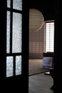 古民家宿コロク-Kominka Stay Koroku- في فوجيمي: غرفة مع نافذة وأثاث خفيف كبير