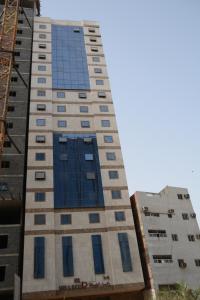 een hoog gebouw met blauwe ramen bij Rakhaa Al Deafah Hotel in Mekka