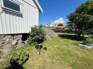 a barbecue grill in the grass next to a building at Havsutsikt på Vrångö! in Gothenburg