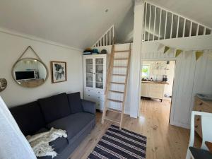 a living room with a blue couch and a ladder at Havsutsikt på Vrångö! in Gothenburg