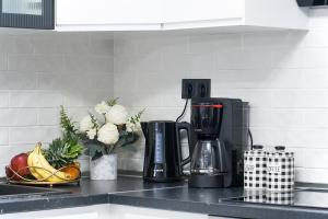 Una encimera de cocina con cafetera, frutas y flores. en Frina's House Skiathos, en Skiathos 12 fotos más