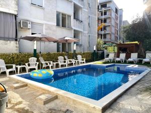 piscina con sedie e ombrellone di Apartments Pribilovic a Budua