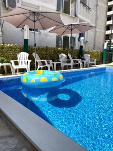una piscina con zattera, sedie e ombrelloni gonfiabili di Apartments Pribilovic a Budua