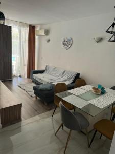 un soggiorno con tavolo, sedie e un letto di Апартамент на солнечном берегу a Sunny Beach Altre 14 foto