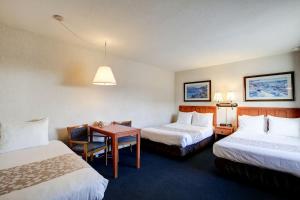 een hotelkamer met 2 bedden en een tafel bij Newport Channel Inn in Newport Beach