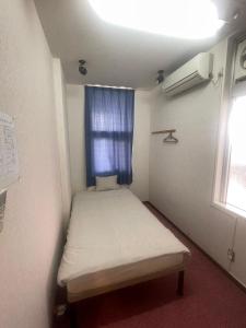 ゲストハウス あぱらぎ Guesthouse Aparagi في جزيرة إيشيغاكي: غرفة صغيرة بها سرير ونافذة
