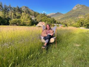 a woman sitting in a chair in a field at Camping White Rock in Castellane
