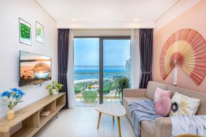 Una sala de estar con un sofá y vista al mar. en The Sóng Apartment -Minh Thy's Homestay Vũng Tàu, en Vung Tau