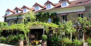a large building with a sign in front of it at LOGIS Hôtel & Restaurant - Au Bord du Lac in Saint-Rémy-lès-Chevreuse