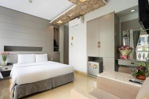 ein Schlafzimmer mit einem großen weißen Bett und einem Sofa in der Unterkunft Lucky Star Hotel Q5 in Ho-Chi-Minh-Stadt