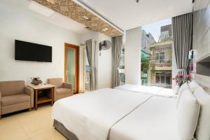 ein Schlafzimmer mit einem großen weißen Bett und einem Fenster in der Unterkunft Lucky Star Hotel Q5 in Ho-Chi-Minh-Stadt