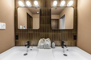 a bathroom with two sinks and two mirrors at Nihon Iro in Shizuoka