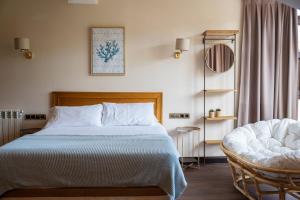 a bedroom with a bed and a chair at Apartamentos San Jorge in Nueva de Llanes