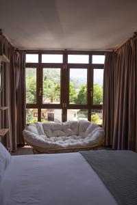 a bedroom with a couch in front of a window at Apartamentos San Jorge in Nueva de Llanes