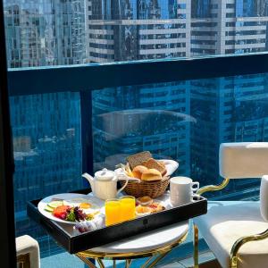 a tray of breakfast food on a table on a balcony at Emirates Grand Hotel in Dubai