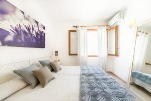 a bedroom with a large bed and a painting on the wall at Apartment Voltor 2 C By SunVillas Mallorca in Pollença
