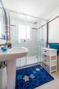 a bathroom with a sink and a shower and a blue rug at Apartment Voltor 2 C By SunVillas Mallorca in Pollença +14 photos