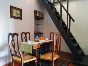 a dining room with a table with chairs and a staircase at Palazzo Ninci in Civitella in Val di Chiana