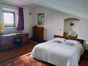 a bedroom with a bed and a desk and a window at Palazzo Ninci in Civitella in Val di Chiana