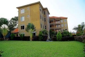 a large building with a yard in front of it at Lishi Resort Hotel in Kampala