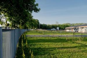 a fence next to a field of grass next to a building at Camper Park TOCAMPER in Władysławowo