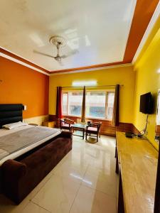 a bedroom with orange walls and a bed and a table at Hotel Park Hills in Jammu +6 photos