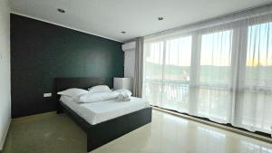 a bedroom with a bed and a large window at Yes Home in Călimăneşti