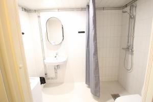 a bathroom with a shower and a sink and a mirror at Forenom Serviced Apartments Hämeenlinna Katuma 3 in Hämeenlinna +29 photos