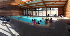 a group of people sitting in a swimming pool at camping haipenée in Saint-Quentin-en-Tourmont