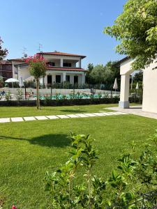 a house in a yard with a green lawn at RESIDENCE FIORE ROSSO in Sirmione