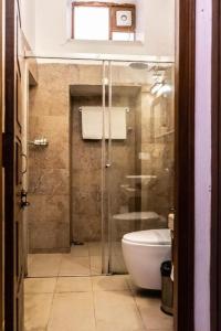 a bathroom with a toilet and a glass shower at Devnadi Hotel in Haridwār