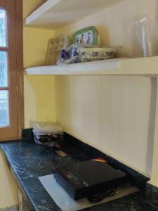 a room with a counter with a shelf on the wall at Namaste Amritsar Homestay in Amritsar