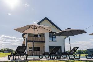 a group of chairs and umbrellas in front of a building at Apartmaji Živa in Gornja Radgona
