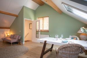 a living room with a white table and chairs at Boerderij appartement De Casterie in Bornerbroek