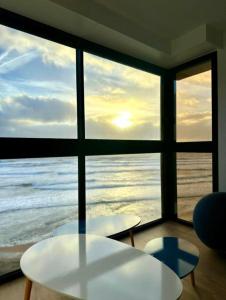 Habitación con 2 mesas y vistas al océano en Appartement au pied de la plage, vue imprenable sur la mer, en Les Sables-dʼOlonne