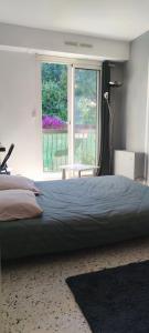 une chambre avec un grand lit et une grande fenêtre dans l'établissement F1 - 8MIN DE LA PLAGE - 5MIN TRAMWAY, à Nice 2 autres photos