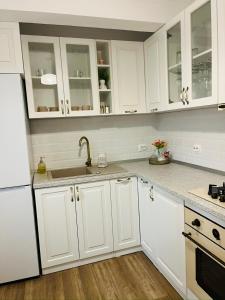 Una cocina con gabinetes blancos y un fregadero. en Dream Rooms, en Hunedoara