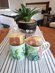 a table with two cups of cakes and a plant at Cozy Corner in Groblersdal