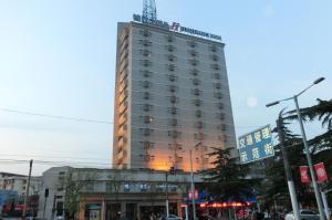 un edificio alto con una grúa encima en Jinjiang Inn Luoyang Wangcheng Park, en Luoyang