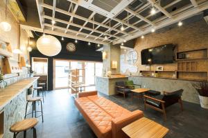 a restaurant with a couch and tables and a bar at Kotori Coworking & Hostel Kotohira in Kotohira