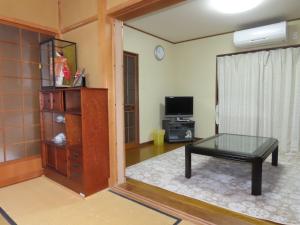 uma sala de estar com uma mesa de centro e uma televisão em SORAMACHI - Vacation STAY 14338 em Takayama
