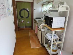 uma pequena cozinha com um micro-ondas e um fogão em SORAMACHI - Vacation STAY 14338 em Takayama