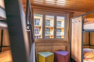 una piccola camera con finestra e due sgabelli di Eiger Lodge Easy a Grindelwald