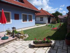 a backyard of a house with a yard with red flowers at Apartment in Balatonbereny - Balaton 18043 in Balatonberény