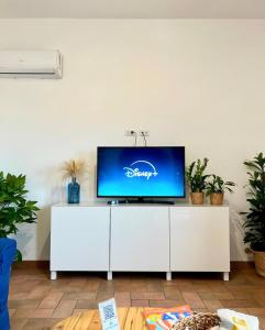 a flat screen tv sitting on top of a white cabinet at Sea Breeze House in Fiumicino
